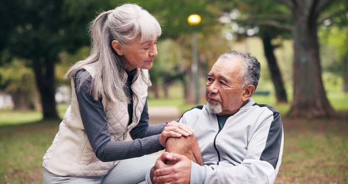Fitness, knee pain and old couple at park with arthritis, stiff bones and accident outdoor. Senior man, woman and help or support for joint problem, muscle or leg injury and interracial relationship
