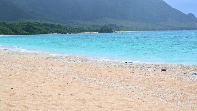 エメラルドグリーンの海と白い砂浜が広がる石垣島の美しいビーチと山並み