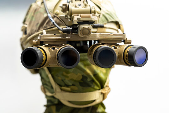 Military night vision goggles mounted on tactical helmet in close frontal perspective. Panoramic four lens optical device attached to special forces combat headgear.