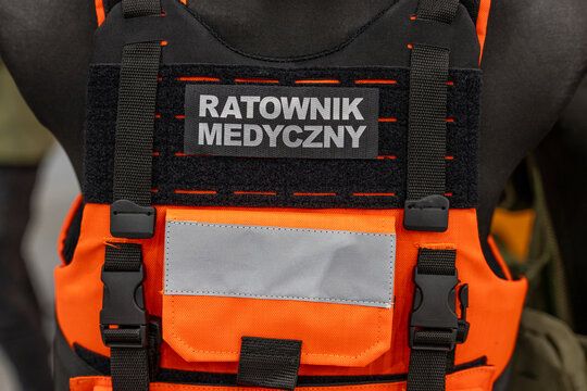Paramedic tactical vest badge on orange emergency rescue plate carrier. Emergency medical technician patch displayed on medical response uniform equipment.