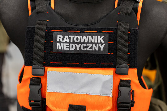 Paramedic tactical vest badge on orange emergency rescue plate carrier. "Ratownik Medyczny" patch displayed on medical response uniform equipment.