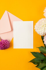 Blank greeting card mockup with pink envelope and white and purple dahlias flowers © vimart