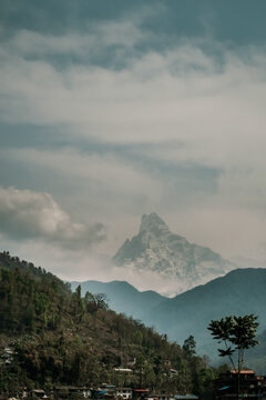 Mountain peak towering over forested hills and village landscape