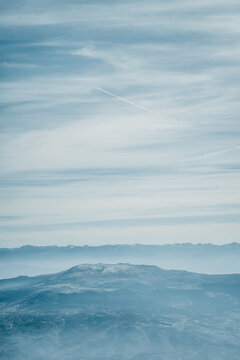 Mountain landscape with distant mountain range beneath cloudy sky