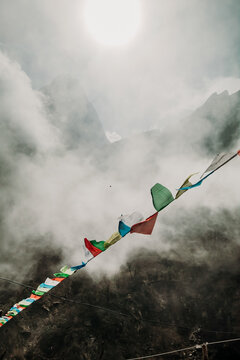 Prayer flags fluttering over misty rocky mountains