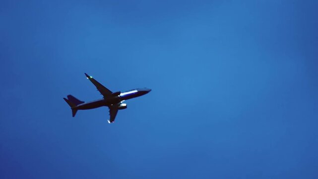 A large jet passenger plane is flying emergency landing through the twilight sky on a cloudy day. The sky is dark and cloudy