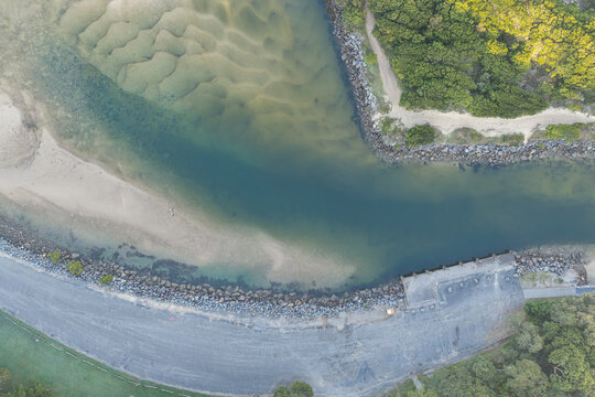 Downward aerial view of natural sand patterns visible beneath the clear tidal water of Back Creek at South West Rocks, New South Wales, Australia.