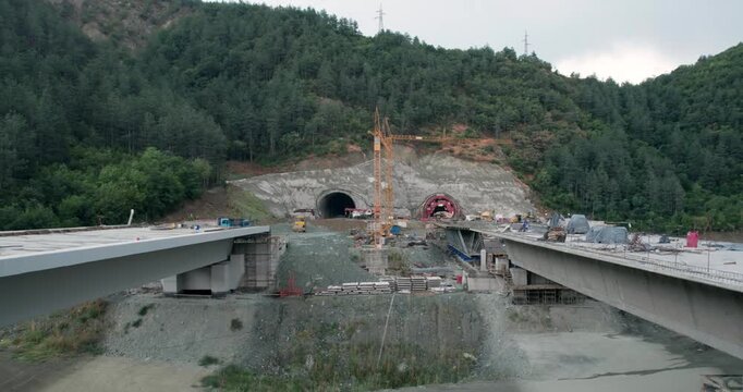 A construction site with a large tunnel being built at new highway, aerial shot