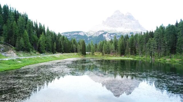 Wide view of mountain lake and green shores in the Dolomites Italy