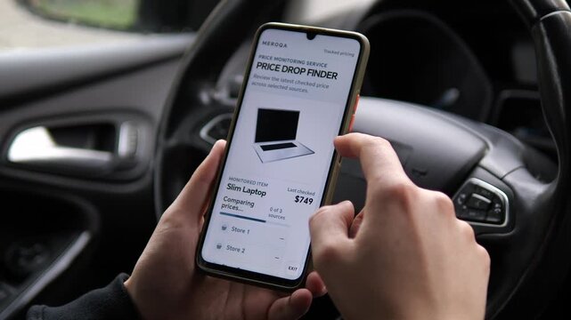 Person checks a laptop price on a smartphone as a monitoring service compares stores and detects a lower offer, highlighting smart shopping and real-time price tracking.