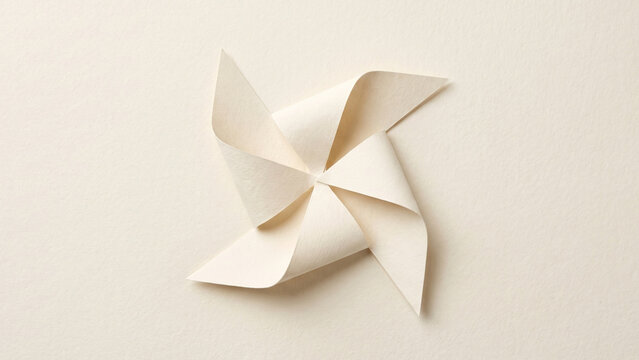 Cream paper craft pinwheel windmill flat lay on a matching cream background