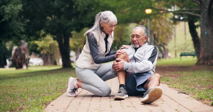 Fitness, knee injury and old couple at park with arthritis, stiff bones and accident outdoor. Senior man, woman and help or support for joint problem, muscle or sore leg and interracial relationship