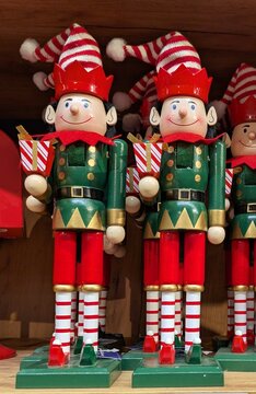 Decoraci&oacute;n navide&ntilde;a. Grupo de figuras de madera de elfos de Santa Claus como cascanueces, sujetando una caja de regalo, en el estante de una tienda