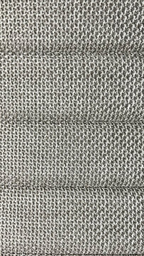 Primer plano de una tela tejida de color gris neutro con una textura r&uacute;stica y l&iacute;neas acolchadas ideales para fondos de dise&ntilde;o