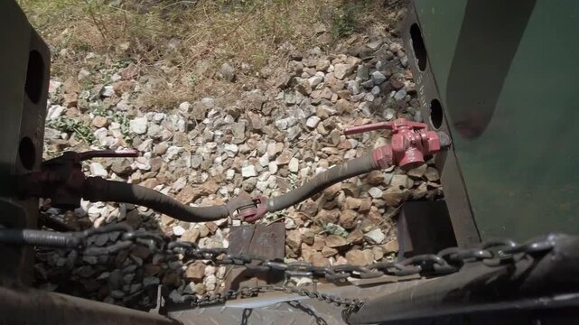 Traveling train connection between carriages, A chain is hanging from a door handle. The chain is attached to a metal object