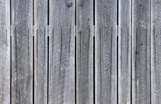 Weathered gray wooden plank fence texture with detailed grain