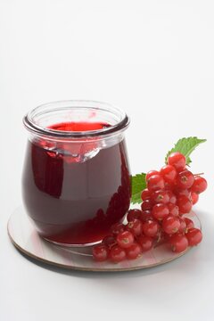 Redcurrant jelly with fresh redcurrants and leaf decoration on dish