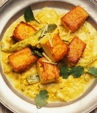 Tofu curry with fried Tofu, cilantro, and ginger in yellow curry sauce