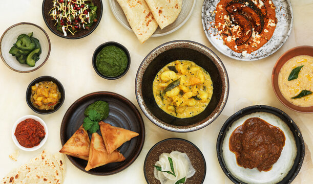 Indian dinner featuring samosas, potato curry, roti bread