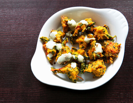 Spinach pakora fried snack with white sauce in bowl