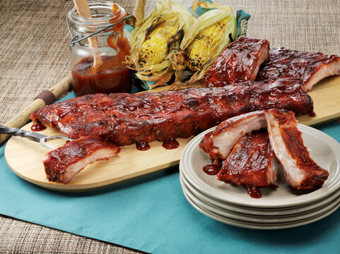 BBQ baby back ribs with barbecue sauce and grilled sweet corn