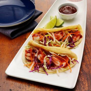 Shrimp tacos with coleslaw and BBQ sauce