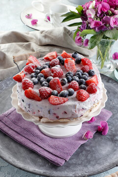 Cake with mascarpone cream and fresh berries on meringue base