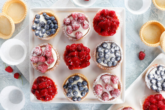 Berry tartlets arranged in sudoku pattern on white plate