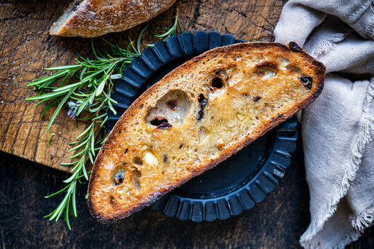 Toasted sourdough olive bread on a black plate