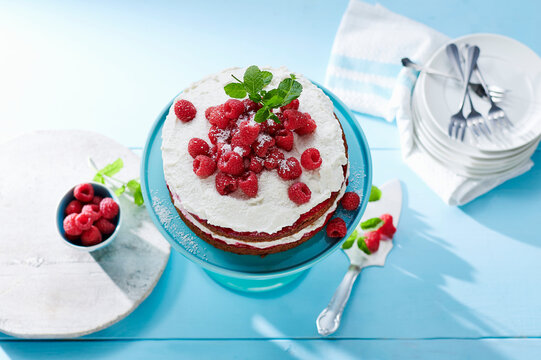Vegan Naked Cake topped with raspberries and coconut cream