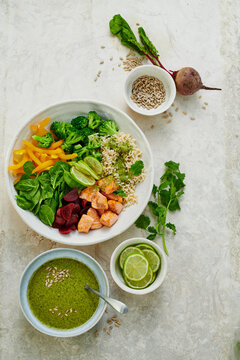 Super bowl with roasted salmon, rice, vegetables, and green sauce