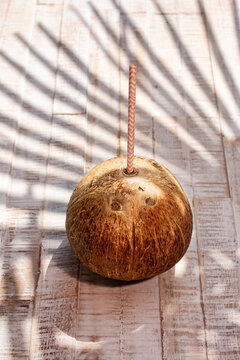 Coconut with paper drinking straw on wooden surface outdoors
