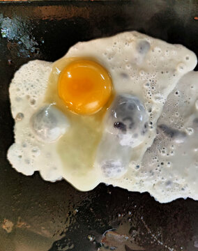 Fried egg cooking in frying pan overhead view
