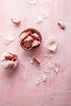 Garlic cloves and bulb on pink textured surface
