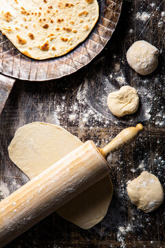 Preparing tortillas with a wooden rolling pin