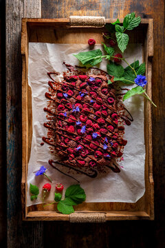 Chickpea brownie topped with raspberries and chocolate drizzle