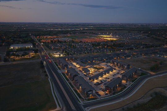 Aerial view of illuminated residential apartment complexes and suburban streets in Greeley, Colorado, United States.