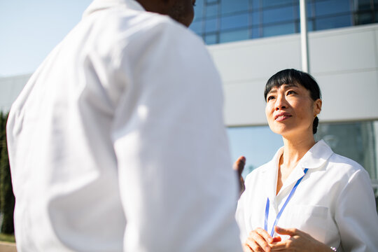 Female doctor listening to colleague outside a hospital