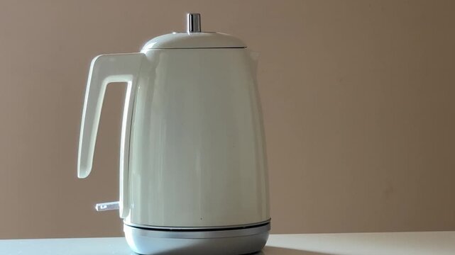 Hand Placing Electric Kettle On Base And Turning On