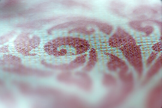 Close-up of intricate currency note design with detailed patterns and vivid colors