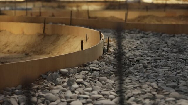 Curved pathway formwork with gravel base prepared for concrete pouring