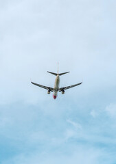 Commercial passenger aircraft photographed from below as it flies across a pale blue sky. The aircraft is positioned centrally with extensive negative space, making the image suitable for travel adver © Наташа Фомина