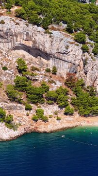 Croatia, aerial view of rocky cliff, pine trees and blue sea