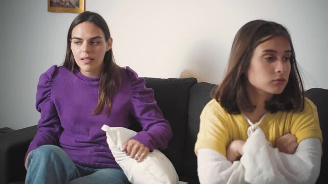 Two young Latina friends arguing angrily and struggling to resolve their differences. Concept of friendship conflict, emotional tension, communication problems, disagreement, unresolved issues, and re