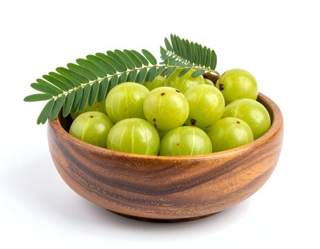Wooden bowl of amla fruit with leaf on white background