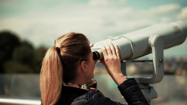 Tourist Looking Through Coin Operated Binoculars At Scenic City Panorama