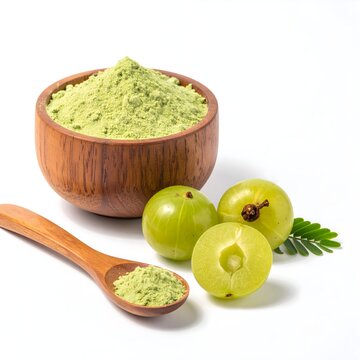 Wooden bowl and spoon of dried amla powder with amla fruit and leaf on white background