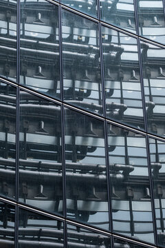 Glass building facade with structural lines and mechanical elements creating dense geometric architecture in a layered exterior view