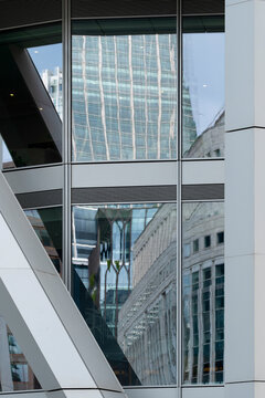 Structural frame and reflective windows create layered modern architecture with urban depth in an abstract exterior view of a contemporary building