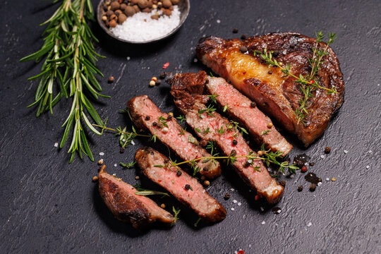 Overhead steakhouse meal with knife and seasoning - on a rustic platter